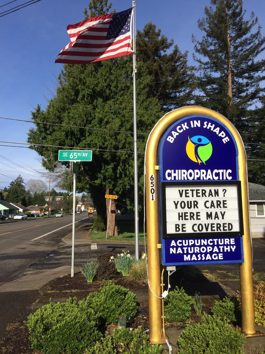 Back In Shape Chiropractic office sign in Milwaukie, Oregon welcoming veterans and noting VA-covered care